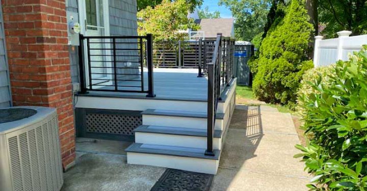 A backyard deck of a house made from composite decking material and metal railings